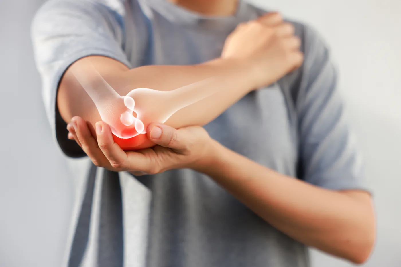 Person holding their elbow with the joint highlighted to show pain inside the elbow