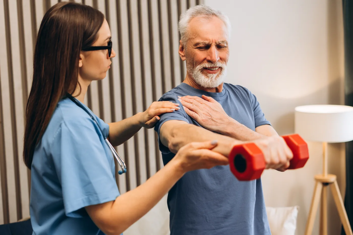 Older adult performing guided shoulder exercises with a physical therapist during recovery